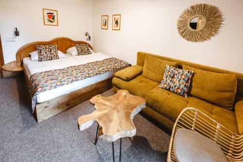 a bedroom with a bed and a couch and a table at Hotel Frýdl in Prague