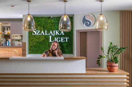 a sign for a bar with a woman at Szalajka Liget Hotel és Apartmanházak in Szilvásvárad