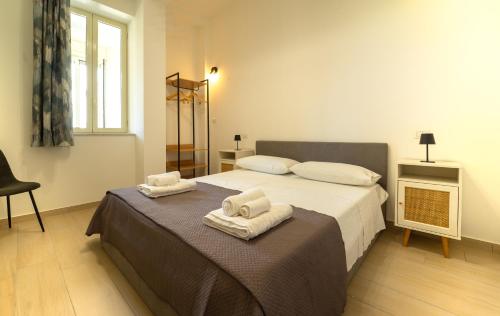 a bedroom with a bed with towels on it at Le rose di Mimmo Casa vacanze in Barcellona-Pozzo di Gotto