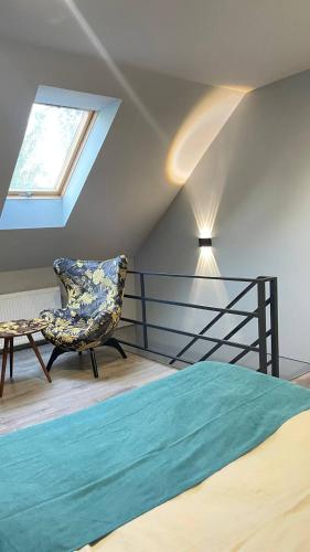 a bedroom with a bed and a chair and a window at Двох рівнях апартамент для 3 осіб N1 in Chernivtsi