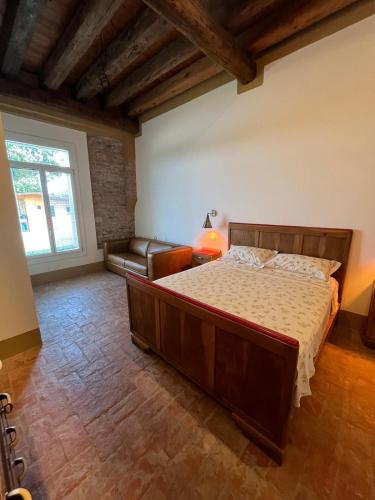 a bedroom with a large bed and a couch at Locazione Turistica Le Selve in Saccolongo