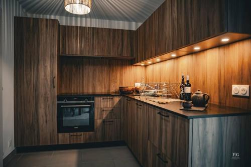 a kitchen with wooden cabinets and a stove top oven at Le Méribel - Terrasse 83m2 - Vue Mont-Blanc in Sallanches