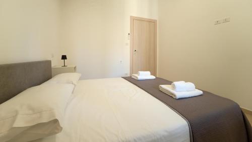 a white bed with two towels on top of it at Le rose di Mimmo Casa vacanze in Barcellona-Pozzo di Gotto