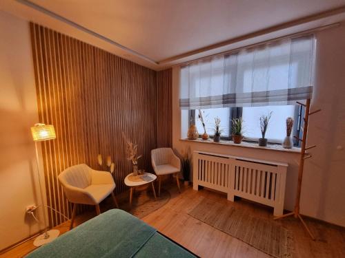 a bedroom with a window with chairs and a table at Malachit Karpacz SPA Hotel in Karpacz