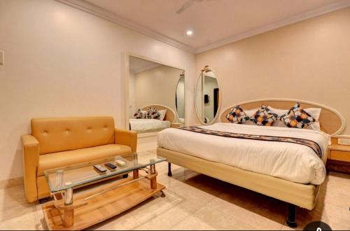 Un dormitorio con una cama, una silla y un espejo. en Hotel Stay Land Inn Versova, en Bombay