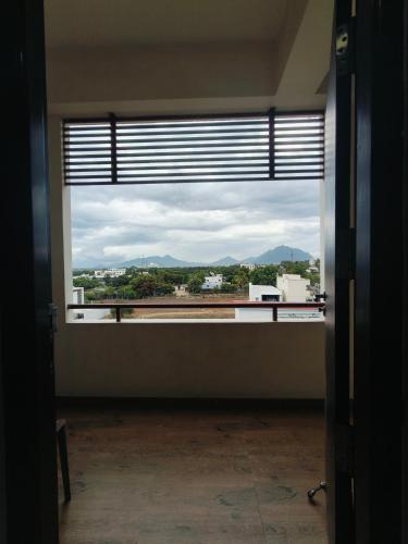 a room with a large window with a view at Holiday Residency Coimbatore in Coimbatore