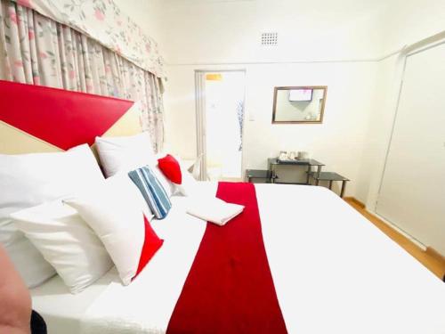 a bedroom with a large white bed with a red headboard at Executive Accommodation Bellville 1 in Bellville