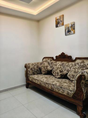 a couch sitting in a room with a white wall at Holiday Residency Coimbatore in Coimbatore