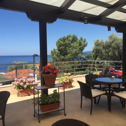 a patio with tables and chairs and a view of the ocean at Apartments Marina in Sveti Stefan