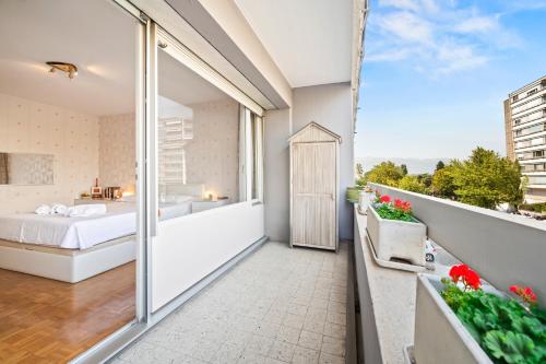 a balcony of a hotel room with a bed and a bathroom at Taverney - Spacieux appartement lumineux aux portes de Genève in Geneva
