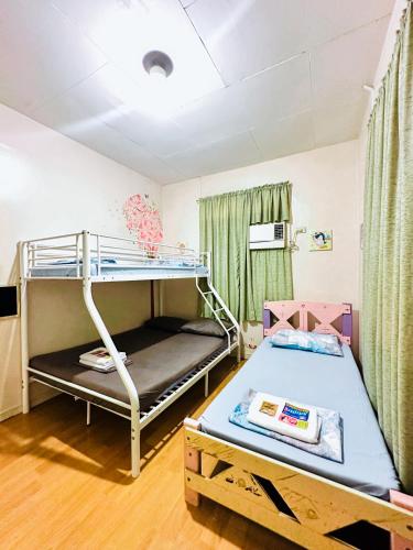 a room with a bunk bed and a bunk bed at Feel at Home Polomolok WiFi 300mbps Netflix 75in TV in Polomolok