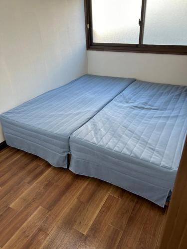 ein großes Bett in einem Zimmer mit Holzboden in der Unterkunft 京橋駅徒歩10分圏内隠れ宿京橋 in Osaka