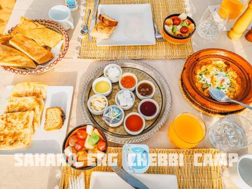 stół z wieloma talerzami jedzenia na nim w obiekcie Sahara Erg Chebbi Camp w mieście Merzouga