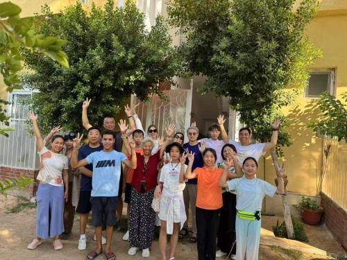 a group of people posing for a picture with their hands up at Karima House in Luxor