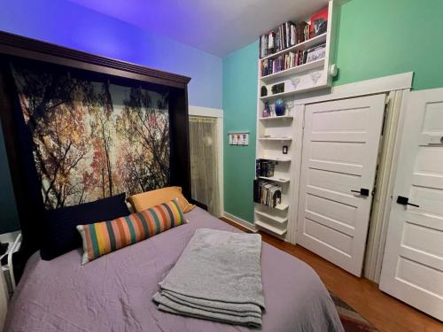 a bedroom with a bed with a large painting on the wall at Room at 4114 in Seattle