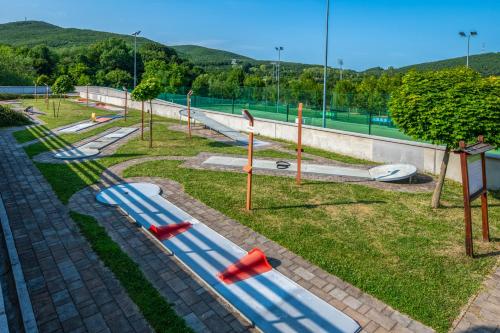 a park with a playground with blue and red slides at Szalajka Liget Hotel és Apartmanházak in Szilvásvárad