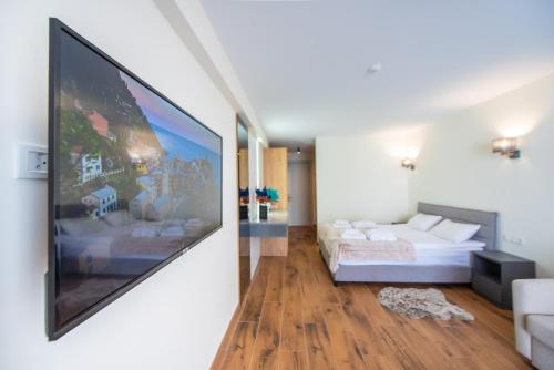 a living room with a large tv on the wall at Go-Gudauri The Atrium Residence in Gudauri