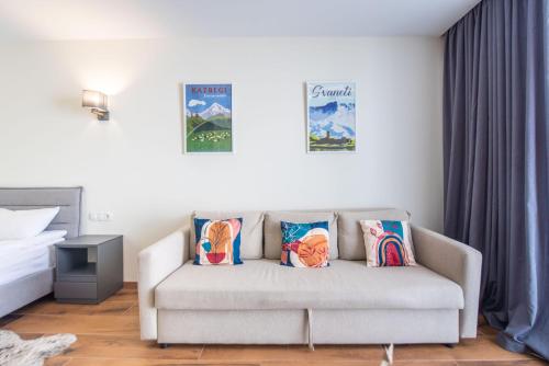 a living room with a couch with pillows at Go-Gudauri The Atrium Residence in Gudauri
