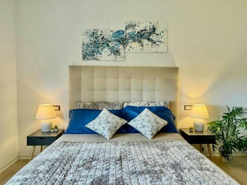 a bedroom with a large bed with blue pillows at Panoramic Villa In The Lucca Hills in Capannori