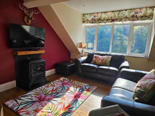 a living room with a couch and a fire place at The Eaves in Lynton, Exmoor, Devon in Lynton