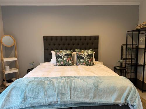 a bedroom with a large bed with two pillows at Robyns Nest Self Catering Studio Cottage No2 in Kloof