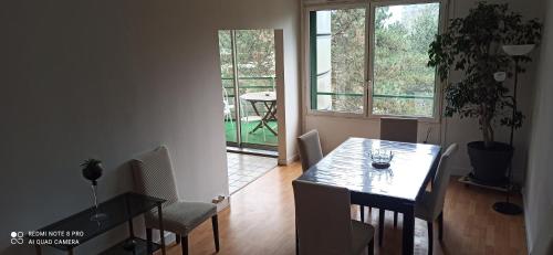 a dining room with a table and chairs and a window at Entre Ville & Nature-Sejour idéal a Massy in Massy