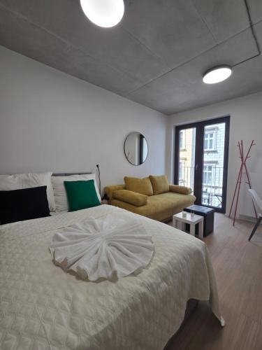a bedroom with a large bed and a couch at Haas Apartments Art with parking, bakery, coffea in Brno
