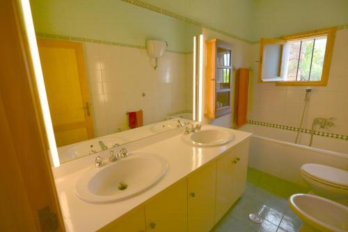 a bathroom with two sinks and a tub and a toilet at Sea View Villa On Monte Argentario in Monte Argentario