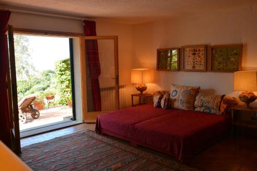 a bedroom with a bed and a sliding glass door at Sea View Villa On Monte Argentario in Monte Argentario