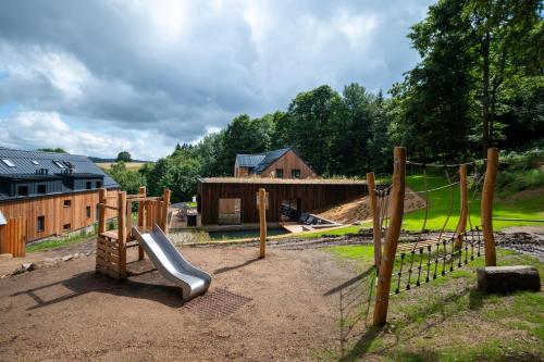 a playground with a slide and a fence at Apartmány Hraničná s privátním wellness in Bedřichov