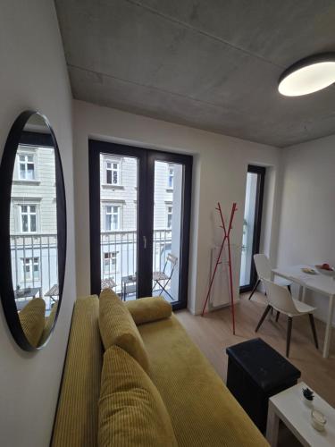 a living room with a couch and a mirror at Haas Apartments Art with parking, bakery, coffea in Brno