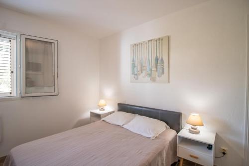 Un dormitorio con una cama con dos mesas y dos lámparas. en Villa Porto Vecchio 8p, en Porto Vecchio