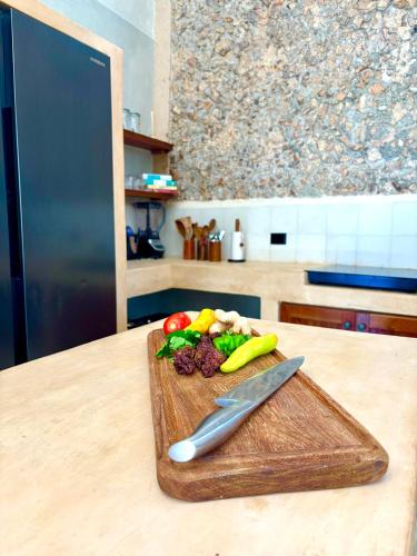 a cutting board with vegetables and a knife on a counter at Casona Tres Culturas,steps away from the Convent in Izamal