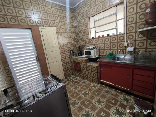 a kitchen with a sink and a microwave at Casa aconchegante em BQ in Barbacena