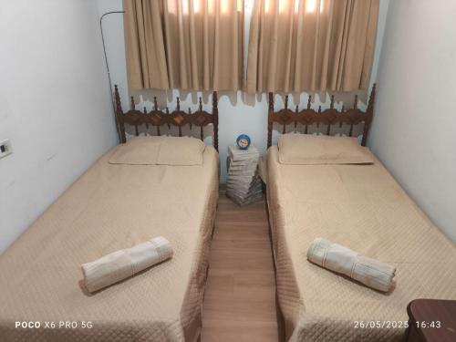 two beds in the corner of a room at Casa aconchegante em BQ in Barbacena