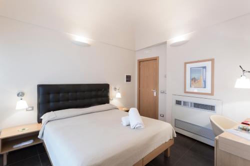 a bedroom with a large bed and a bathroom at Hotel Novecento in Scicli