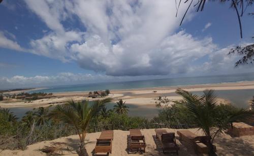 a view of a beach with chairs and the ocean at Stunning sea view, charming beach house in Barra, Mozambique - 4x4 in Miramar