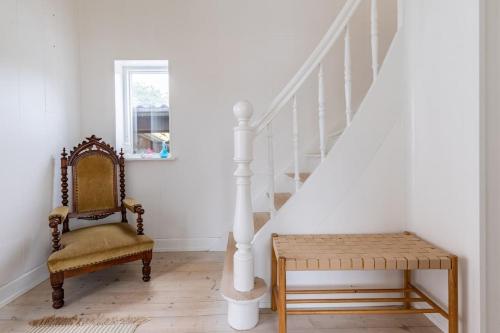 a stairway with a chair and a chair istg at MuremesterVilla ved Hav og Skov in Stubbekøbing
