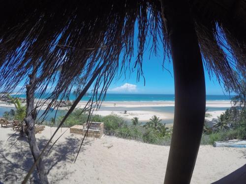 a view of the beach from a straw umbrella at Stunning sea view, charming beach house in Barra, Mozambique - 4x4 in Miramar