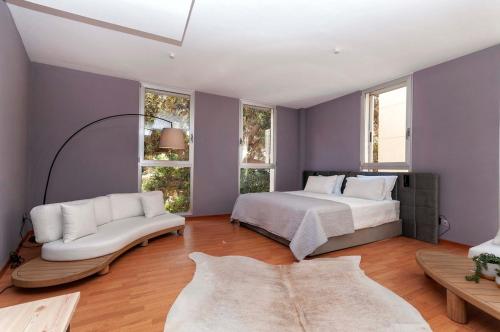 Un dormitorio con una cama y un sofá y ventanas. en Modern 3rd floor loft in Alicante, en Alicante