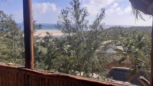 a view of the beach from a window at Stunning sea view, charming beach house in Barra, Mozambique - 4x4 in Miramar