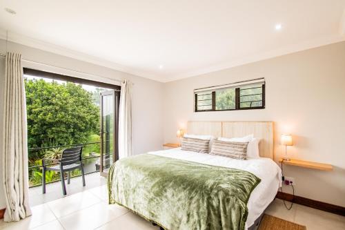 a bedroom with a bed and a large window at Robyns Nest Self Catering Flat No3 in Kloof