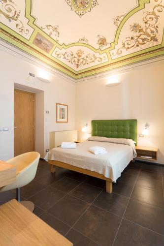 a bedroom with a bed and a tub and a ceiling at Hotel Novecento in Scicli