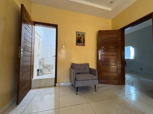 a living room with a chair and a door at Maison d'Hôtes entière Cité Douane Golf Dakar in Dakar