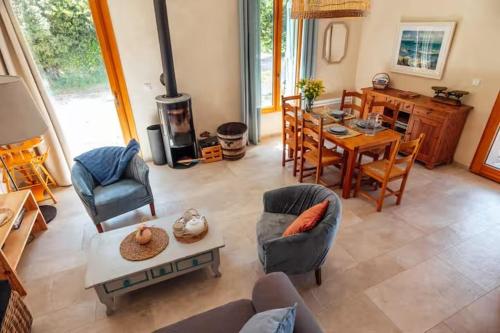 ein Wohnzimmer mit Kamin, Tisch und Stühlen in der Unterkunft Charming House In An Organic Wine Estate in Frontignan