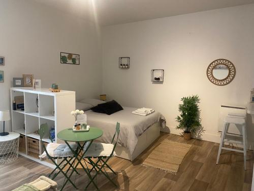 a small bedroom with a bed and a table at Le Studio d'en O, au coeur de la ville haute in Pornic