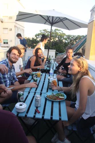 a group of people sitting around a picnic table at The Lights Hostel in Málaga