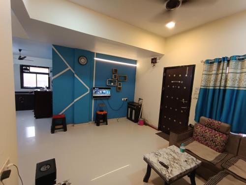 ロナバラにあるPlanet C villa - 3 BHK with private swimming poolの青い壁のリビングルーム(ソファ付)