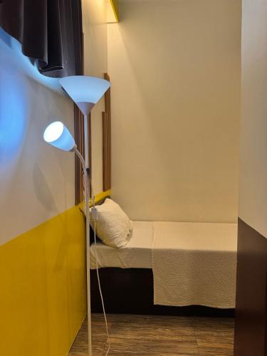 a small room with a bed and a lamp at Z Pension in Dumaguete