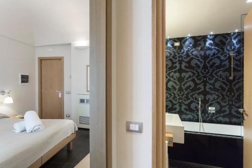 a hotel room with a bed and a bathroom at Hotel Novecento in Scicli